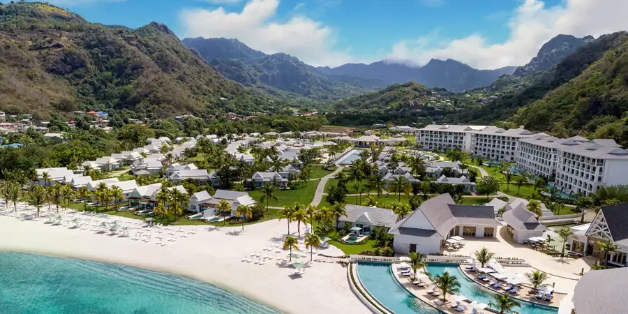 A beachfront Sandals resort nestled against a backdrop of towering mountains
