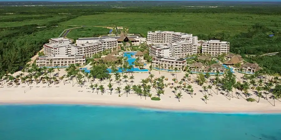 A beachfront all-inclusive resort with turquoise waters and lush greenspace
