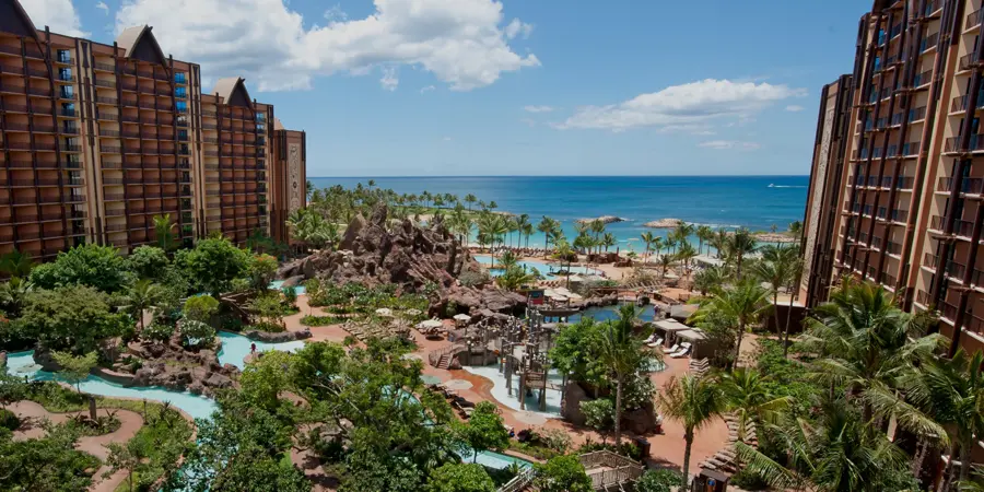 A lush oasis-style pool with the Pacific Ocean in view on the horizon