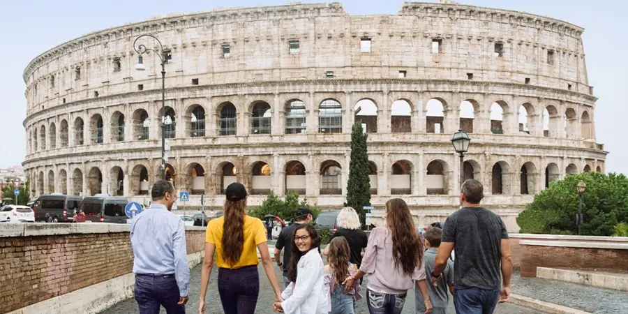 A tour group walks toward Rome's Colosseum